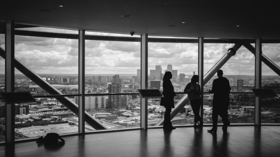 Investors discussing co-ownership of commercial property in an office overlooking a city skyline.