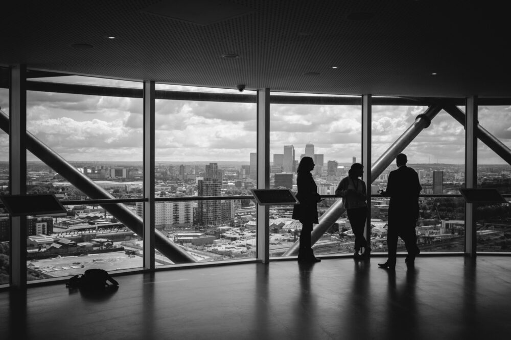 Investors discussing co-ownership of commercial property in an office overlooking a city skyline.