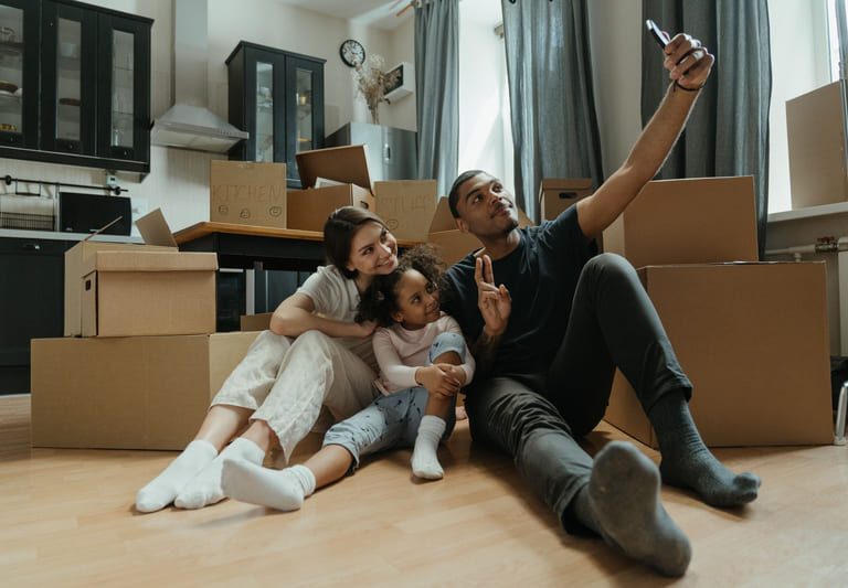 Happy young family taking a selfie while moving into their new home in Pune